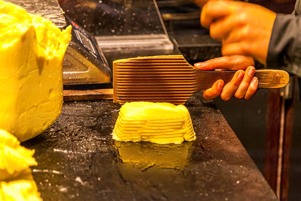 Im Maison de Beurre von Jean-Yves Bordier in Saint Malo schlagen Butter-Paddel Wasser aus der Butter heraus / © Foto: Georg Berg