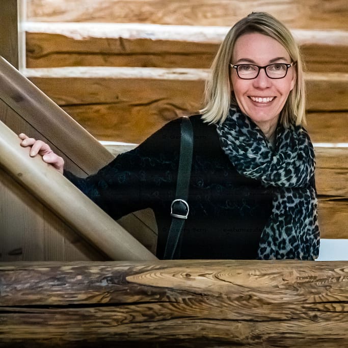 Redakteurin Angela Berg mitten im Gebälk. In vielen Räumen sind die alten Holzbalken offengelegt, werden in Kontrast zu modernen Möbeln gesetzt / © Foto: Georg Berg