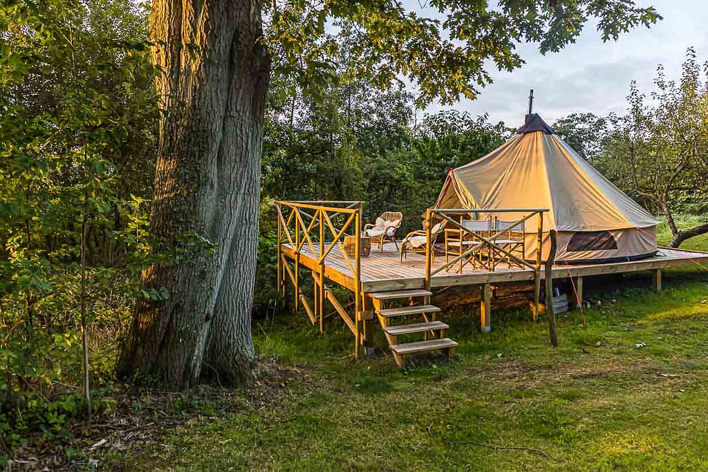 Glamping im Garten der Villa Skovly in Hesselager, Dänemark. Das geräumige Zelt mit Doppelbett steht auf einer Holzterasse im Obstgarten der Villa / © Foto: Georg Berg