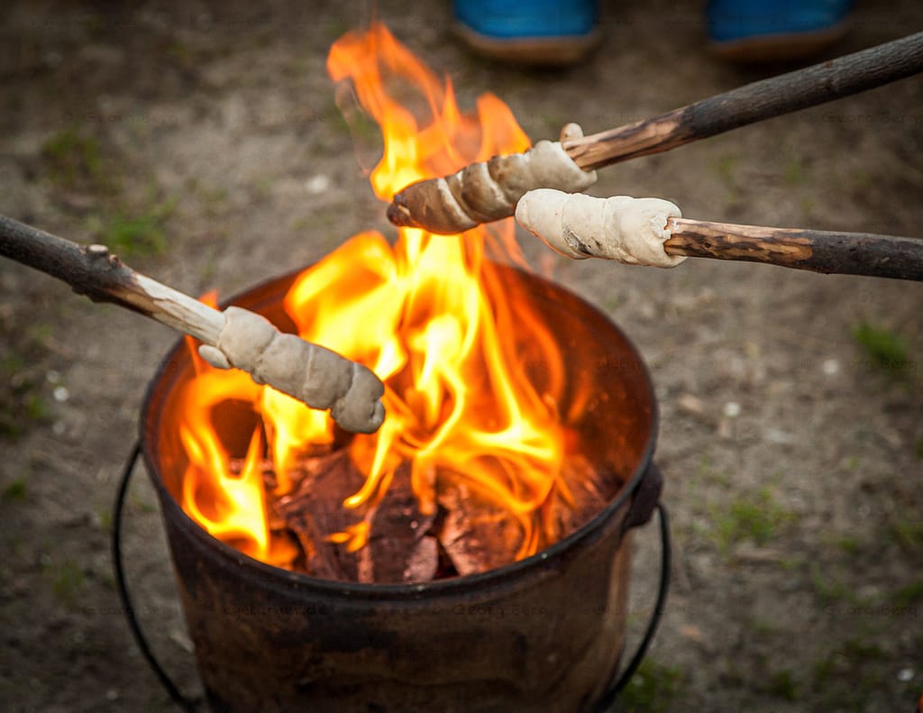 Stockbrot wird auf einem Campingplatz über einem Feuereimer gebacken / © Foto: Georg Berg
