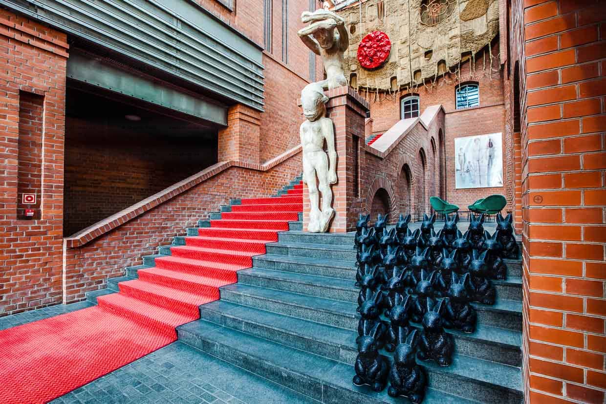 The impressive entrance hall of Hotel Blow up 5050, Poznan. Poland. As a guest, you immediately want to follow the red carpet. It leads past contemporary art such as sculptures and photographs. The hotel guest is led directly to the equally gigantic hotel bar / © Photo: Georg Berg