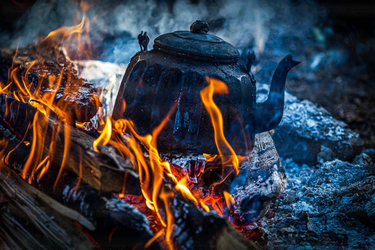 Verrußter Kessel auf einem Holzfeuer / © Foto: Georg Berg