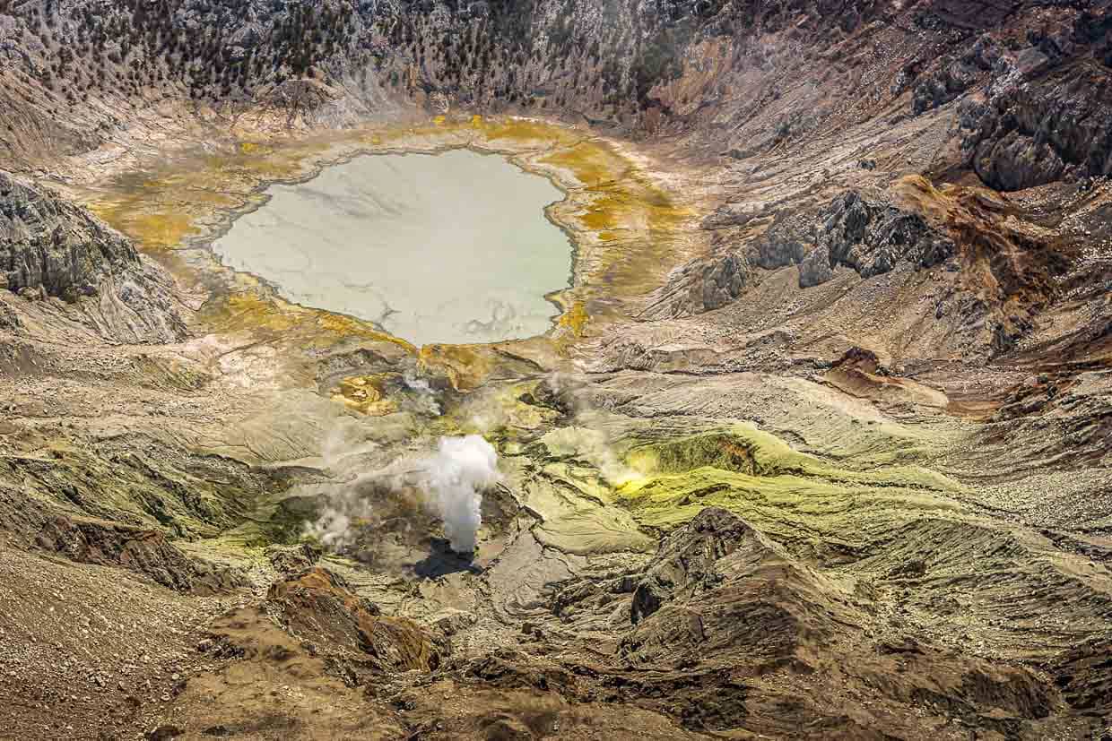 Über dem Gunung Sirung riecht es nach Schwefel und neben einem grauen Kratersee stößt der Vulkan regelmäßig Dampffontänen aus / © Foto: Georg Berg