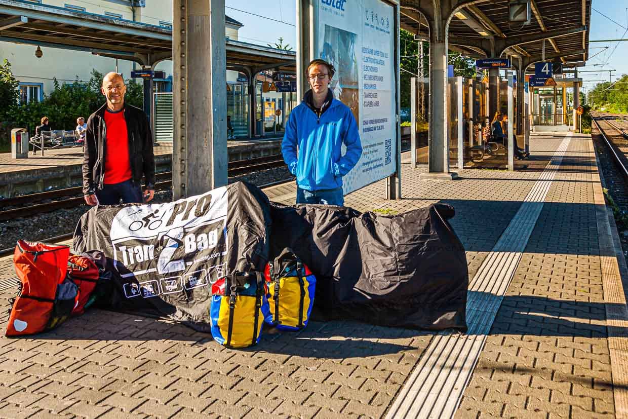 Georg Berg mit Sohn Julius auf dem Bahnsteig. Das Gepäck besteht aus Satteltaschen und verpackten Fahrrädern / © Foto: Georg Berg