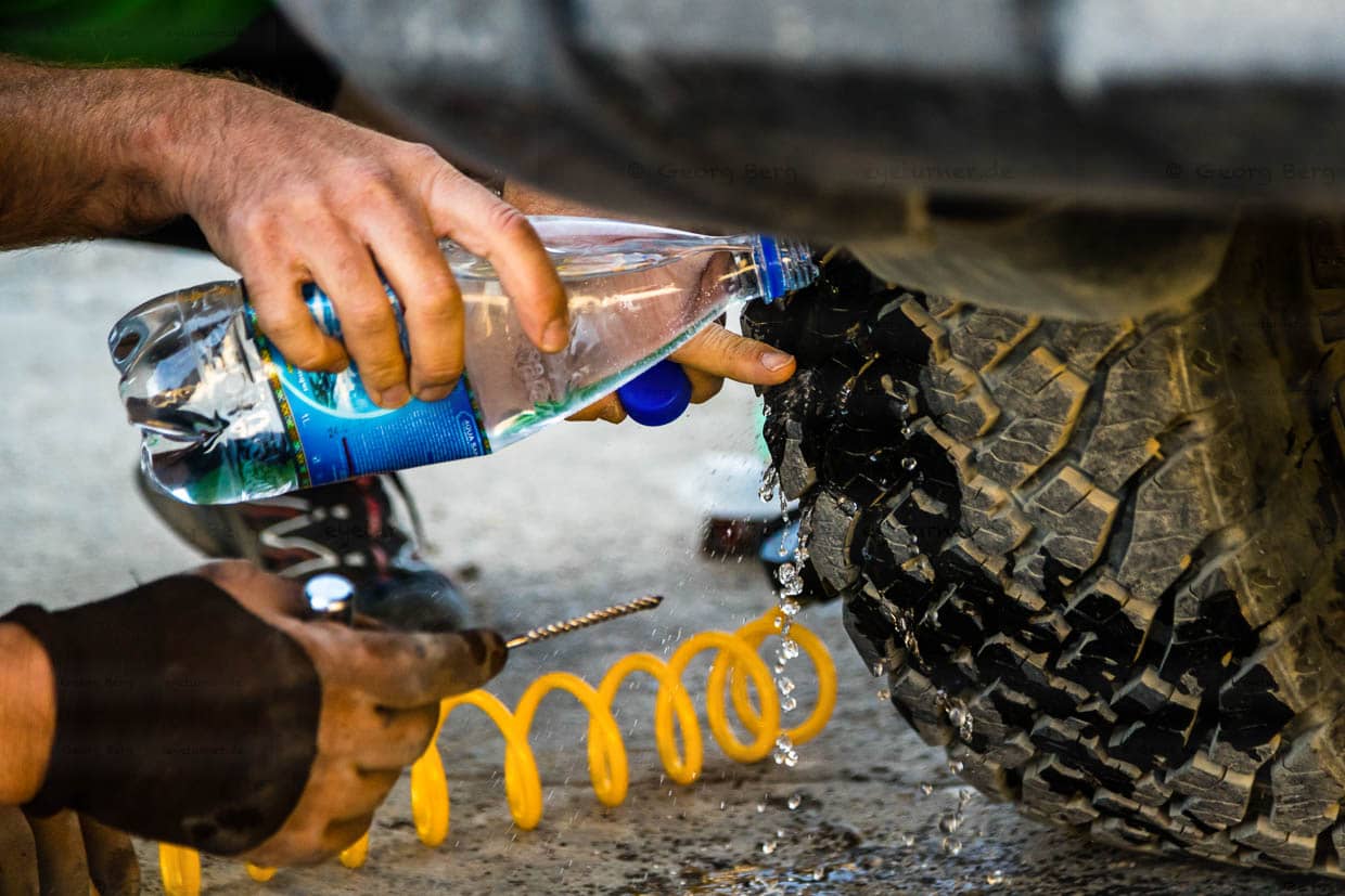 Kompressor, Wasserflasche, Bohrer und ein vulkanisierbarer Gummifaden reichen dem Reifen, um weitere 1.000 Kilometer auf Schotterpisten durchzuhalten / © Foto: Georg Berg