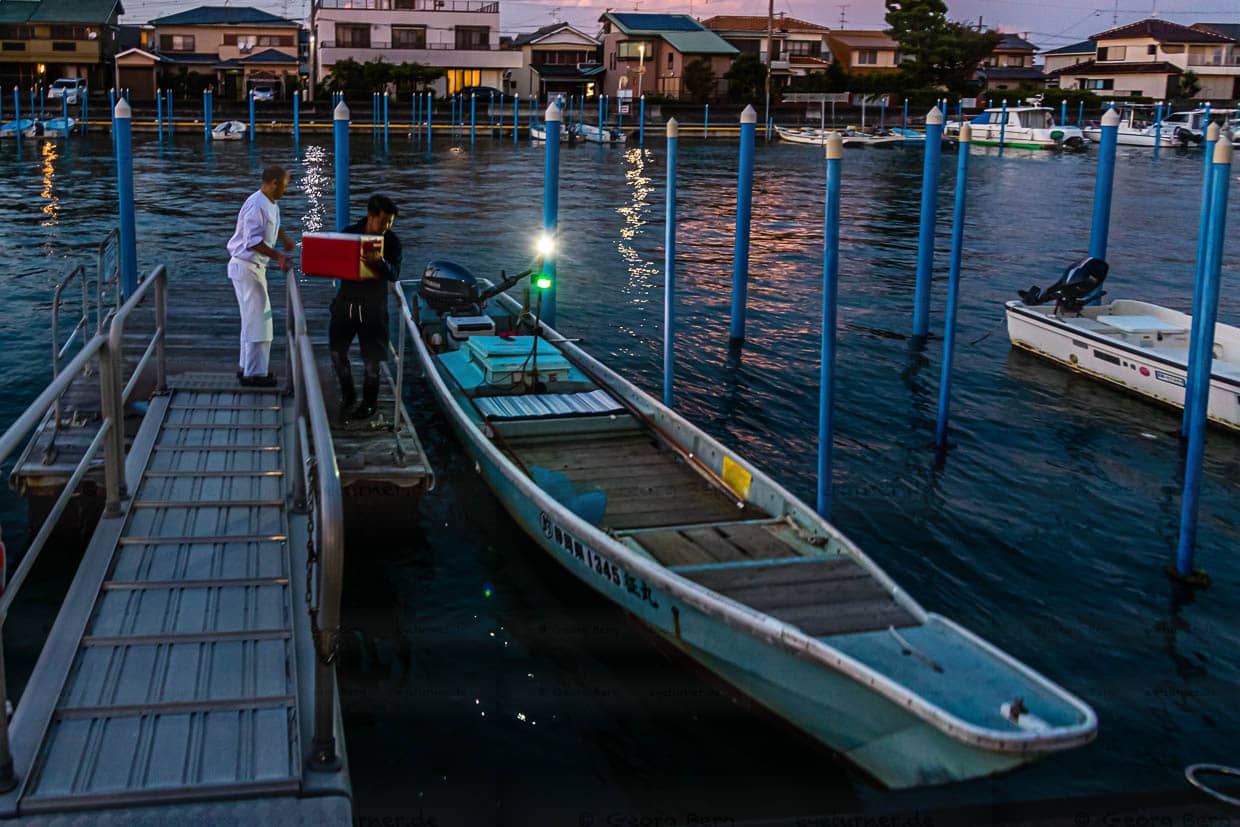 Die Sonne geht gerade unter am Hamana See. Zeit, das Boot mit dem Fischerei-Werkzeug und der Kühlbox für den Fang von Fischen und Krebsen zu beladen / © Foto: Georg Berg