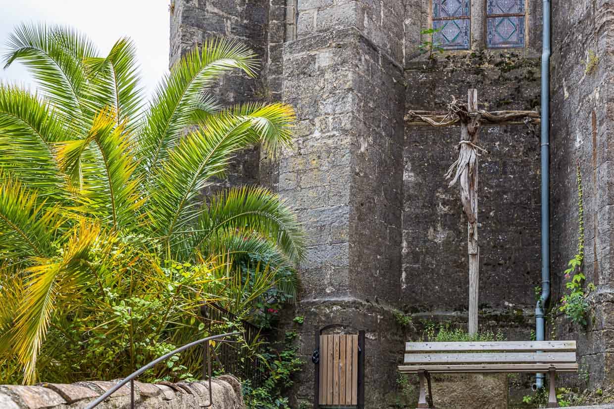 Vor der Kirche von Mourèze steht ein Kreuz, das der Künstler Emmanuel Cometto aus unbearbeitetem Holz geschaffen hat / © Foto: Georg Berg