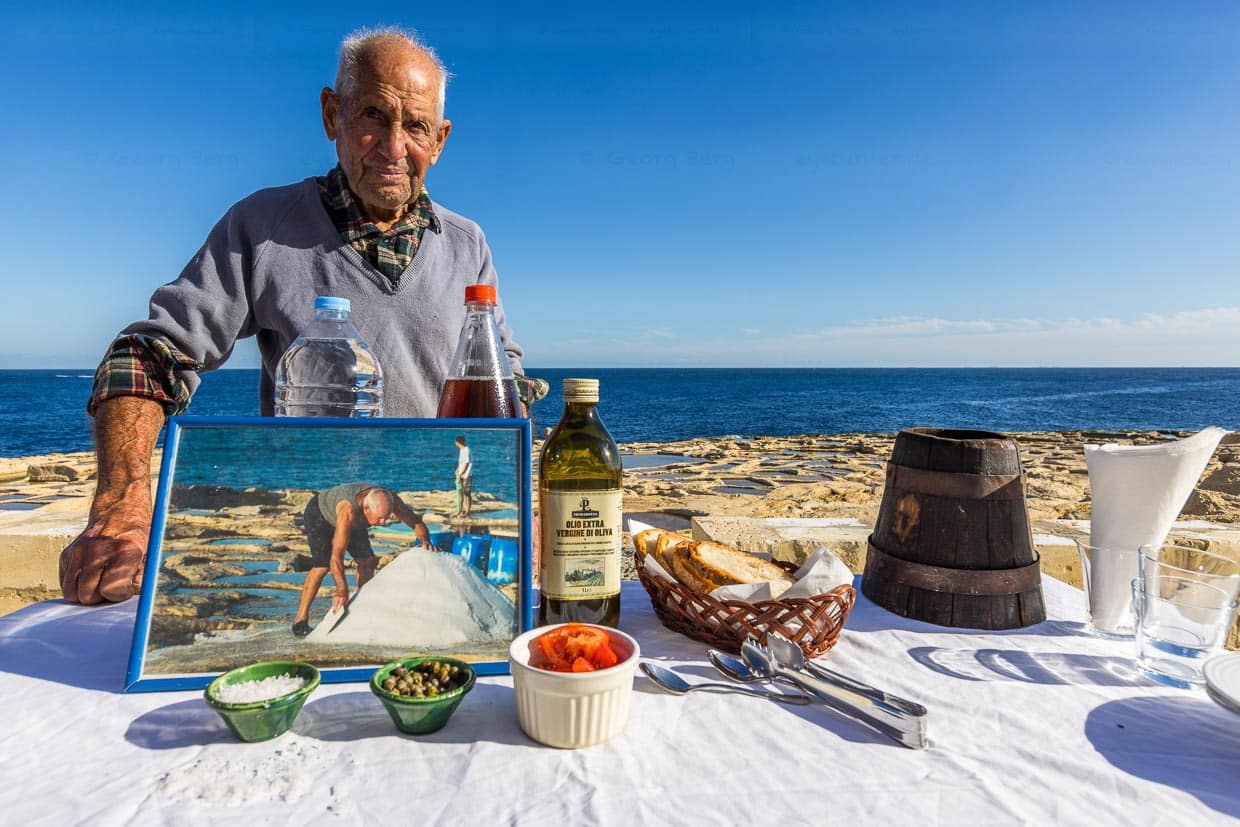 Żaren Darmanin, Salzbauer auf Malta mit einem Foto, das ihn bei der Salzernte im Sommer zeigt / © Foto: Georg Berg