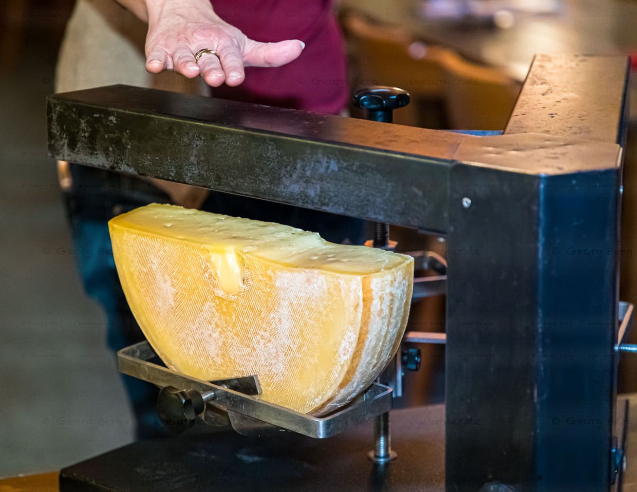Heißes Ding! Der 3er Raclette-Ofen ist eine Art Käse-Karussell mit zwei Armen und drei Käsehalterungen. Der Käse rotiert und die Raclette-Gesellschaft bekommt stetig flüssigen Käse auf den Teller gestrichen / © Foto: Georg Berg