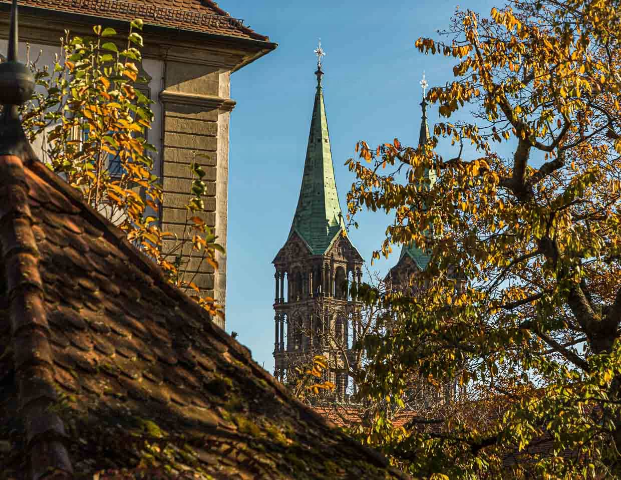 Die Türme des Bamberger Doms St. Peter und St. Georg hinter einem Kastanienbaum und anderen Gebäuden der Bergstadt Bamberg / © Foto: Georg Berg